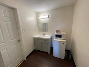 a small bathroom with a sink and a microwave at Tourist Inn in Absecon