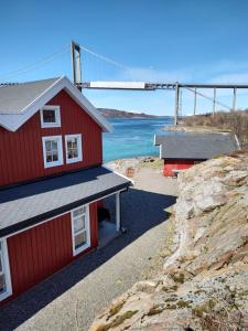 due edifici rossi su una collina con un ponte sullo sfondo di Tjeldsundbrua Overnatting - Sjøhus1 a Evenskjer