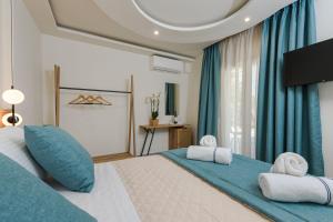 a bedroom with a large bed with blue curtains at Alfa Boutique in Kinira