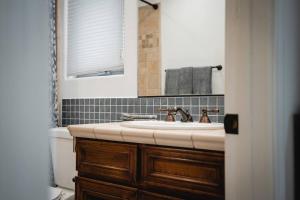 a bathroom with a sink and a toilet and a mirror at The San Diego Studio - Free Parking in San Diego