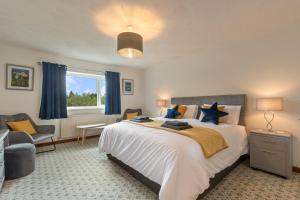 a bedroom with a large bed with blue curtains at Trefelyn Cottage in Saundersfoot