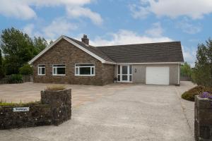 a house with a driveway and a garage at Trefelyn Cottage in Saundersfoot