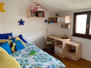 a small bedroom with a bed and a desk at Villa Ecosse in Murter