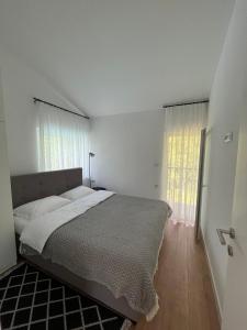 a bedroom with a bed and a large window at Villa Pampas in Banja Luka