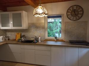 a kitchen with a clock on the wall and a counter at Fajny Domek w Nartach in Narty