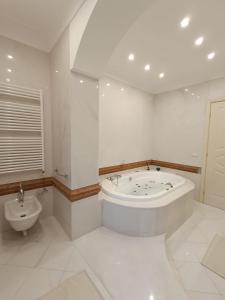 uma casa de banho branca com uma banheira e um WC em Residenza Estea em Tropea