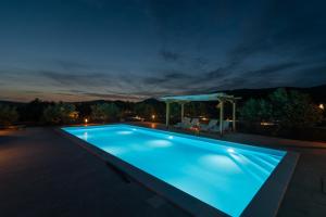 una piscina iluminada por la noche en Kamp Marta, en Marina