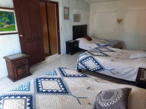 a bedroom with two beds with blue and white blankets at Villa Quintas Del Mar in Mazatlán +2 photos