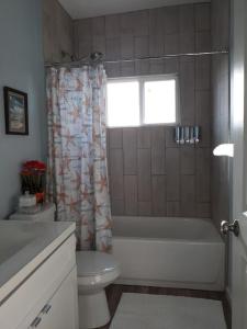 een badkamer met een bad, een toilet en een raam bij Las Casitas on Magnolia Beach - Casita A in Port Lavaca