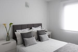 a white bedroom with a large bed with pillows at Ocean apartment in Tías
