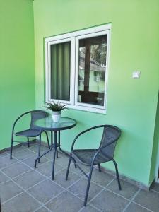 Duas cadeiras e uma mesa num quarto com uma janela em Pool and Villa Splav Dunavac em Futog