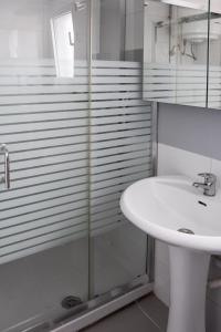 a bathroom with a sink and a glass shower at Ocean apartment in Tías +11 photos