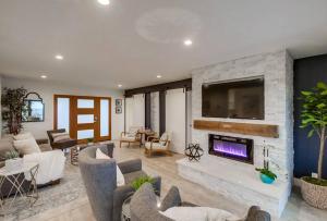 a living room with a fireplace and a tv at The California - On Top of San Diego in a Hot Tub in San Diego