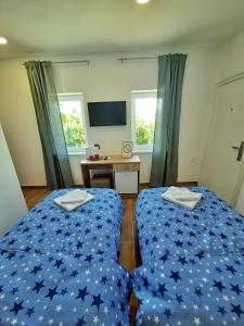 Pool and Villa Splav Dunavac في Futog: غرفة نوم بسريرين مع شراشف زرقاء ومكتب