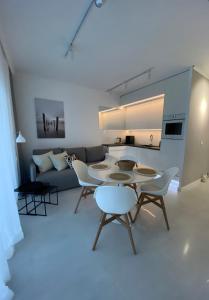 uma sala de estar com uma mesa e cadeiras e um sofá em WhiteWave Apartament Pogorzelica em Pogorzelica