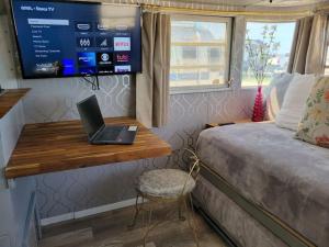 a bedroom with a laptop computer on a desk next to a bed at Maggie At The Beach - 1973 Vintage RV in Port Lavaca
