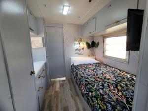a small bedroom with a bed and a window at Maggie At The Beach - 1973 Vintage RV in Port Lavaca
