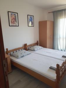 a bedroom with two twin beds and a window at Family apartment Krivokapic in Baošići