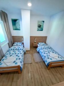 Pool and Villa Splav Dunavac في Futog: وجود سريرين في غرفة ذات أرضيات خشبية