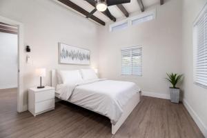 Un dormitorio blanco con una cama y una mesita de noche. en The Hideaway at Lake Ridge 1, en Fort Lauderdale