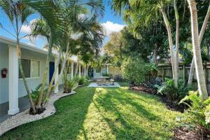 un patio con palmeras y una casa en The Palms at Middle River Terrace 2, en Fort Lauderdale