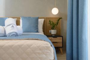 a bedroom with a bed with blue and white pillows at Alfa Boutique in Koinyra