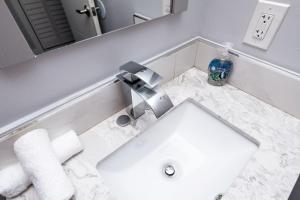 Un baño blanco con lavabo y espejo. en The Palms at Middle River Terrace 4, en Fort Lauderdale 16 fotos más