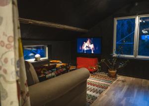 ein Wohnzimmer mit einem Sofa und einem TV in der Unterkunft Lilla Dalbo "Adults only", Ulvön Höga Kusten in Ulvöhamn