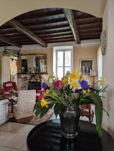 DIMORA MARELLA Patrica - Frosinone في Patrica: إناء من الزهور على طاولة في غرفة المعيشة
