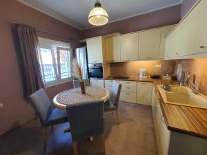 a kitchen with a table and chairs and a kitchen with white cabinets at Lotaki the friendly house in Limenaria
