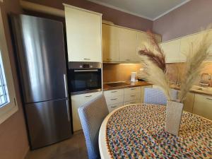 a kitchen with a table and a stainless steel refrigerator at Lotaki the friendly house in Limenaria +22 photos