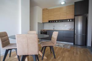 Una cocina con mesa y sillas y un refrigerador. en SUN apartment, en Podgorica
