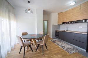 Un comedor con una mesa y sillas en una cocina. en SUN apartment, en Podgorica