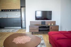 Una sala de estar con un sofá rojo y una mesa. en SUN apartment, en Podgorica