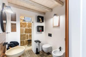 ein Badezimmer mit einem weißen WC und einem Waschbecken in der Unterkunft Othila Home in Noto