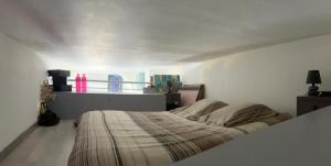 a bedroom with a bed in a white room at Près du Vieux port Studio terrasse vue dégagée église de Saint Jean in Bastia