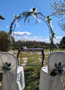 DIMORA MARELLA Patrica - Frosinone في Patrica: حديقة بها كرسيين بيض وطاولة