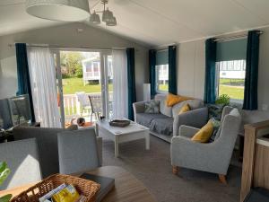 a living room with a couch and a table at 6 Berth Comfy Homely Caravan, Dog Friendly in Belton