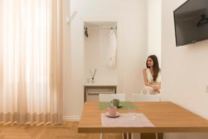 a woman sitting in a chair in a living room at Le Dimore di Puglia - Palazzo Ladogana in Monopoli