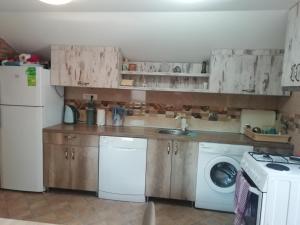 a kitchen with a white refrigerator and a washing machine at PAJO in Sutomore +9 photos