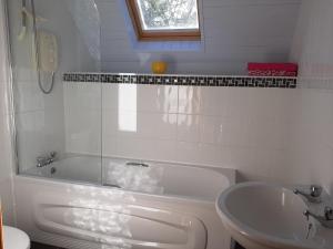 a white bathroom with a tub and a sink at Traditional Cosy Cottage with beautiful views in Westport