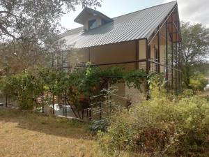 a house with a metal roof and some vines at PAJO in Sutomore