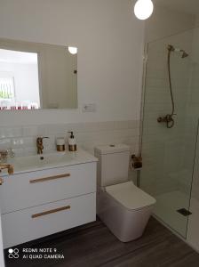y baño con aseo, lavabo y ducha. en Nuevo apartamento Montelouro en Louro