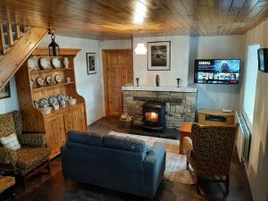 a living room with a couch and a fireplace at Traditional Cosy Cottage with beautiful views in Westport