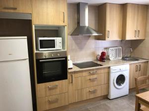 a kitchen with a microwave oven and a dishwasher at BRiSaS DeL NoRTe in Gijón