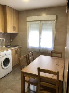 cocina con mesa, sillas, fogones y fregadero en BRiSaS DeL NoRTe, en Gijón 30 fotos más