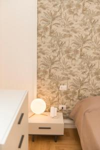 a bedroom with a bed and a nightstand with a wall at Le Dimore di Puglia - Palazzo Ladogana in Monopoli