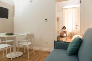 a woman sitting in a chair in a living room at Le Dimore di Puglia - Palazzo Ladogana in Monopoli
