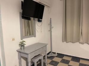een kamer met een tafel en een televisie aan de muur bij Koala Place in Vasiliki