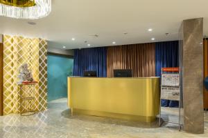 a lobby with a yellow reception desk in a building at Hotel Nalanda in Ahmedabad